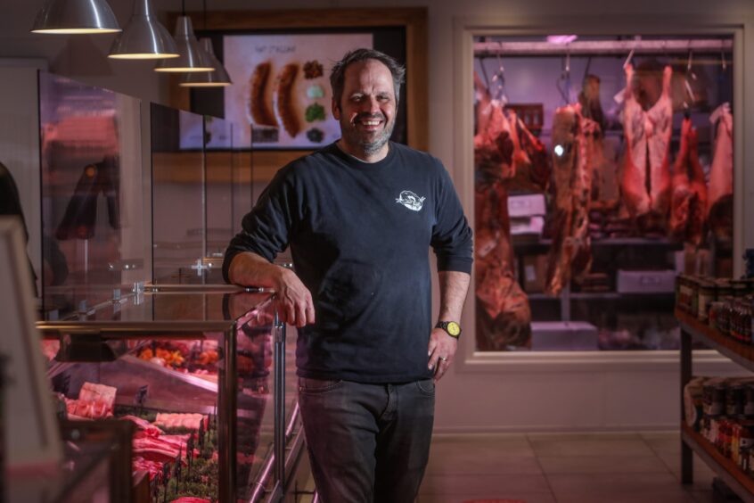 Jonathon standing next to butcher meat