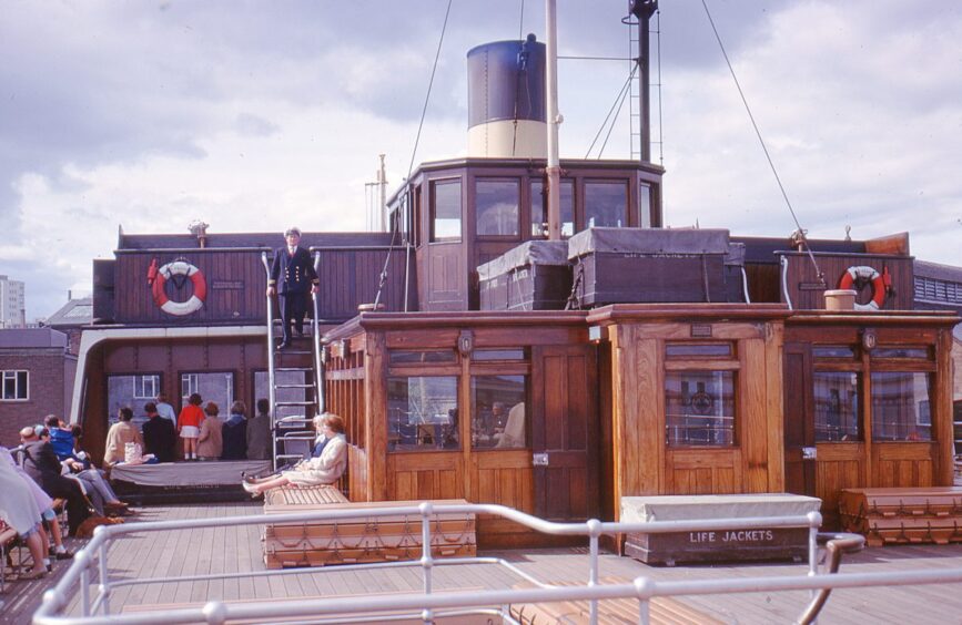 A picture taken on board a Tay Ferry in 1966 shoow a wooden cabin and a man in uniform coming down stairs