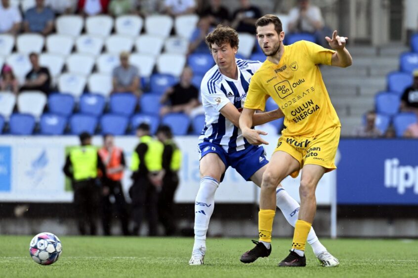 An HJK Helsinki player battles for the ball against an AC Oulu attacker.