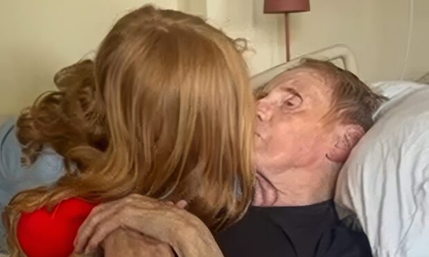Dundee 'wee legend' Ronnie Brady gets final kiss from great granddaughter Darcie. Image: Christine Orrock.