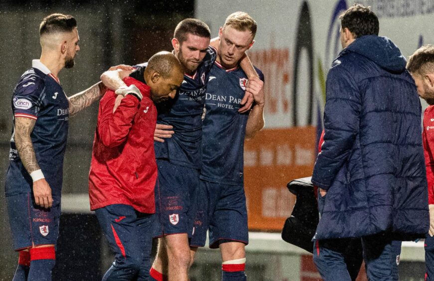 Sam Stanton is helped off the pitch after being injured against Ross County. 