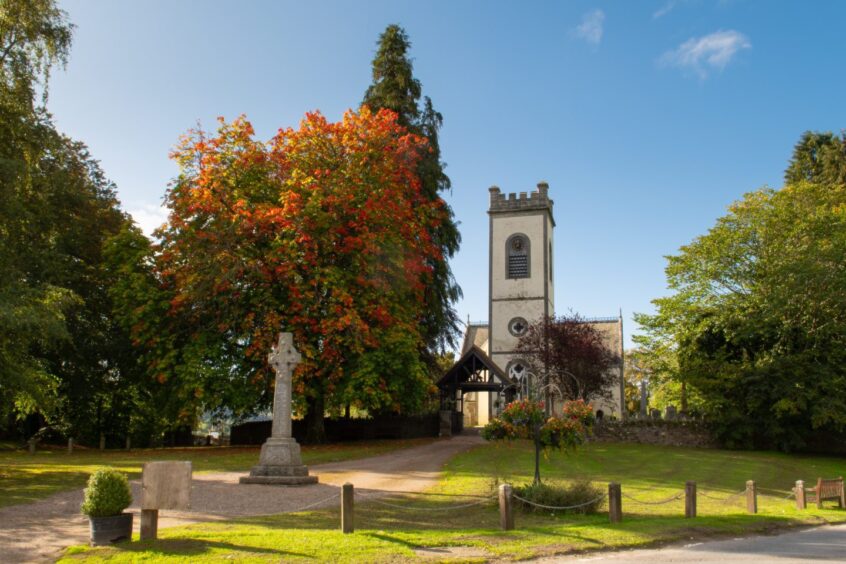Kenmore Church, a small building with white clock tower with war memorial and trees in front