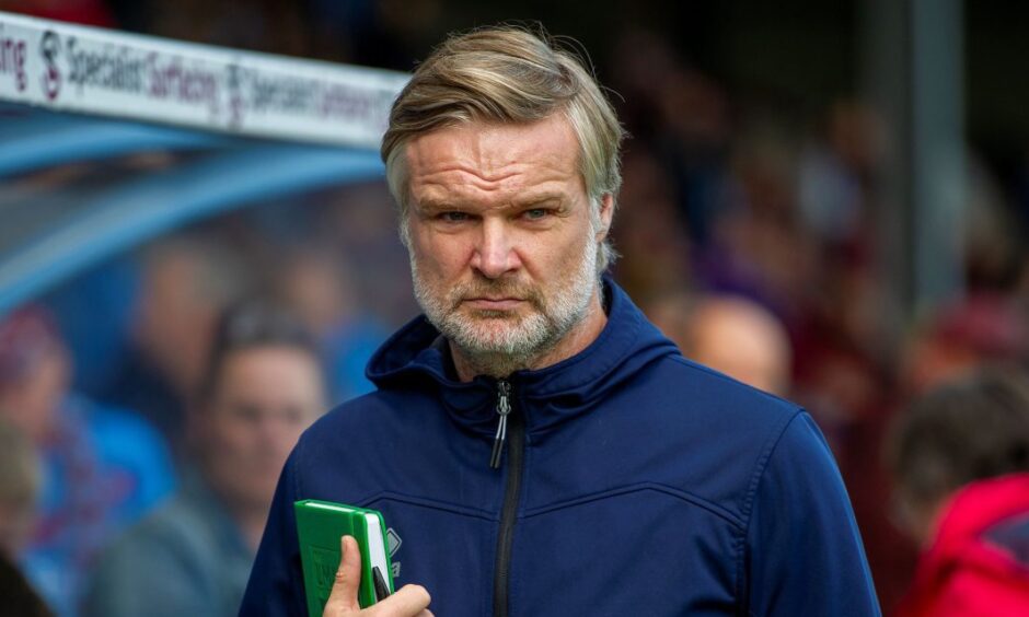 New Dundee FC manager Steven Pressley. on the sidelines in a blue top and carrying a notepad