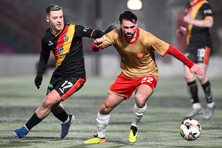 Reghan Tumilty holds off a Partick Thistle player.