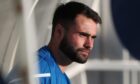 Reghan Tumilty sitting in a dugout while with Hartlepool United.