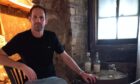 Owner of the Auld Hoose, Scott Henderson, sits at a table in the pub
