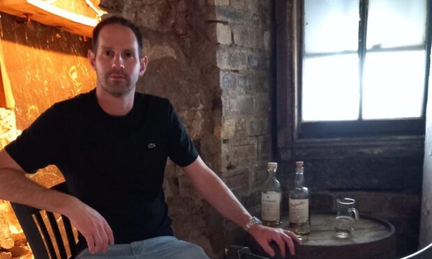 Owner of the Auld Hoose, Scott Henderson, sits at a table in the pub