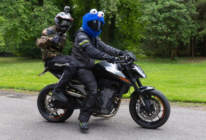 Motorcyclists in fun costume helmets, including a Cookie Monster head, take part in the 2025 Brechin Bike and Trike Fest rideout.