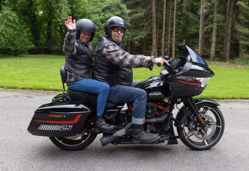 Motorcyclist and passenger wave from a Harley-Davidson during the 2025 Brechin Bike and Trike Fest rideout in Brechin, Angus.