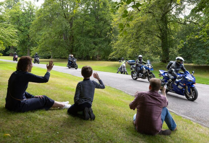 Families wave to motorcyclists during the 2025 Brechin Bike and Trike Fest rideout at Brechin Castle in Angus, Scotland.