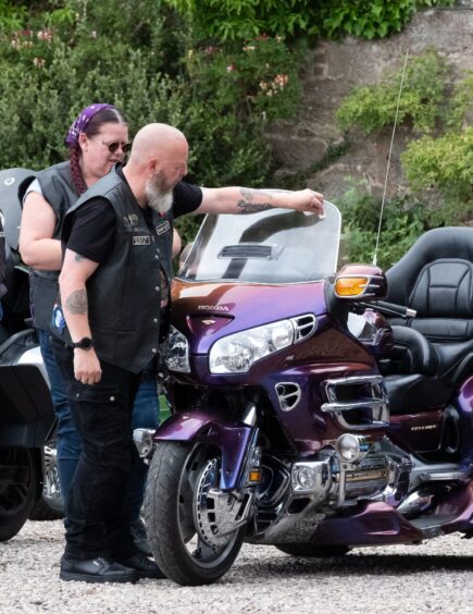 Two bikers examine a purple Honda Gold Wing motorcycle at the 2025 Brechin Bike and Trike Fest at Brechin Castle.