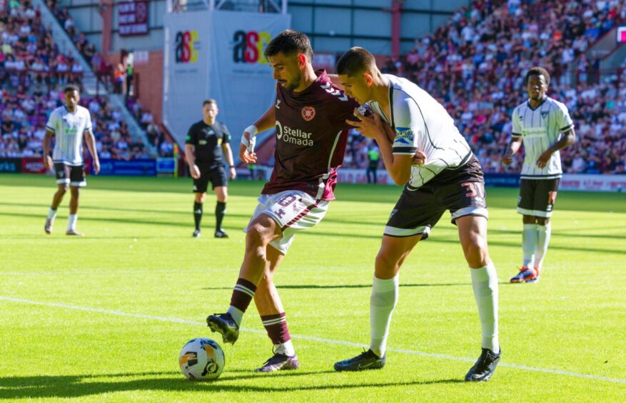 Hearts attacker Claudio Braga holds off Dunfermline defender John Tod as he retains possession.