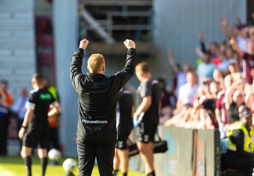 Neil Lennon raises two clenched fists towards the Hearts supporters.