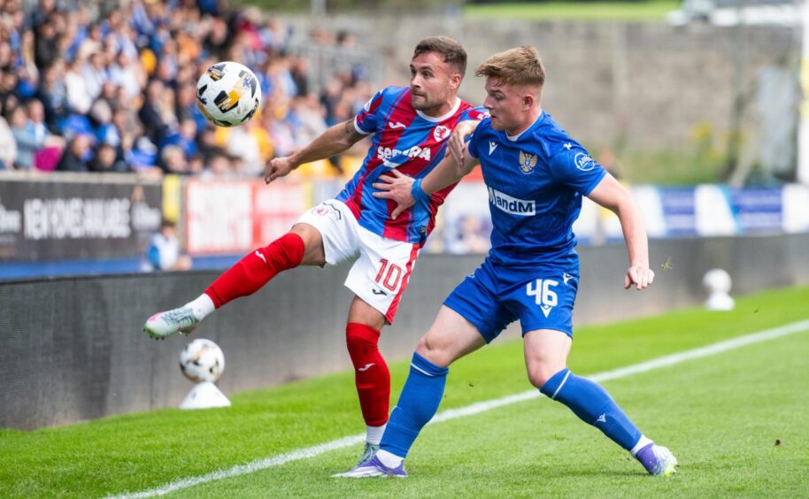 Raith Rovers striker Lewis Vaughan aims a high kick at the ball as he is challenged by St Johnstone's Fran Franczak.