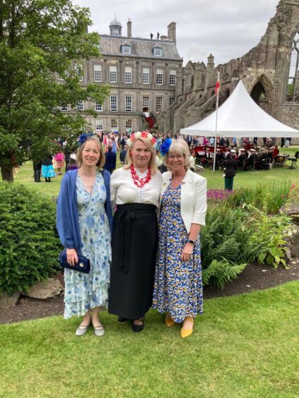 Elizabeth Lindsay, Lidiia Glusach and Frances Smith with garden party tents and palace behind