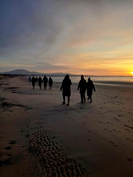 Early morning walkers on Leven beach. 