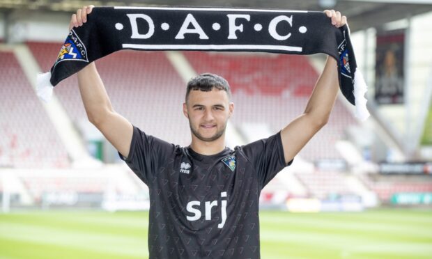 New Dunfermline loan signing Mason Munn holds up a DAFC scarf.