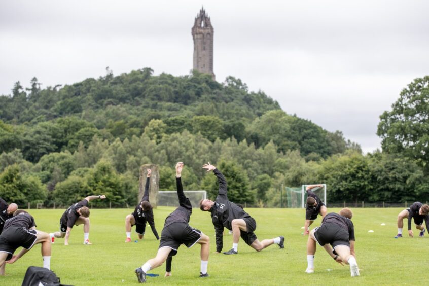 Dunfermline players exercise in front of Stirling's Wallace Monument.