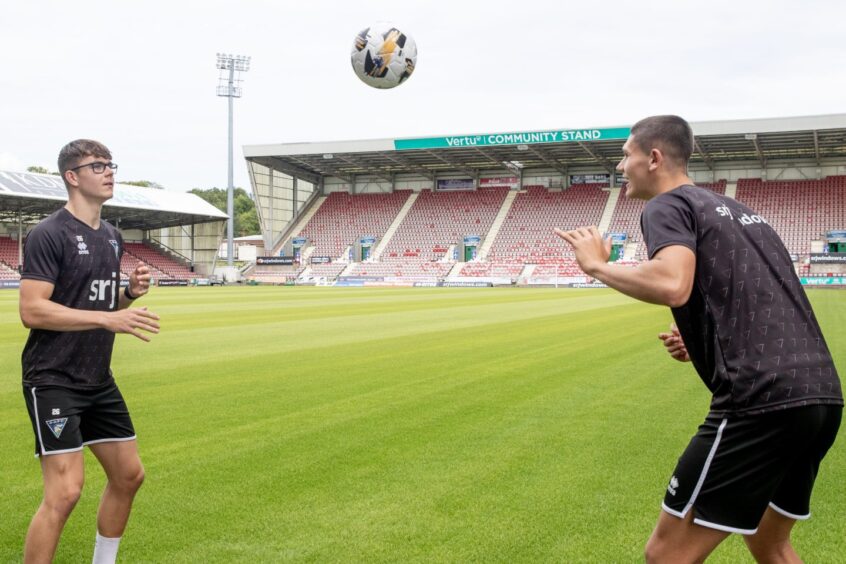 Andrew Tod and brother John head the ball to each other.