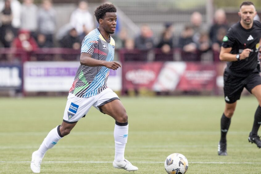 Alfons looks ahead with the ball at his feet.