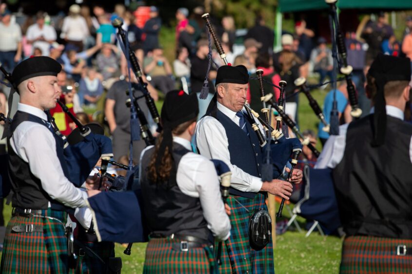 Pipe band members playing bagpipes