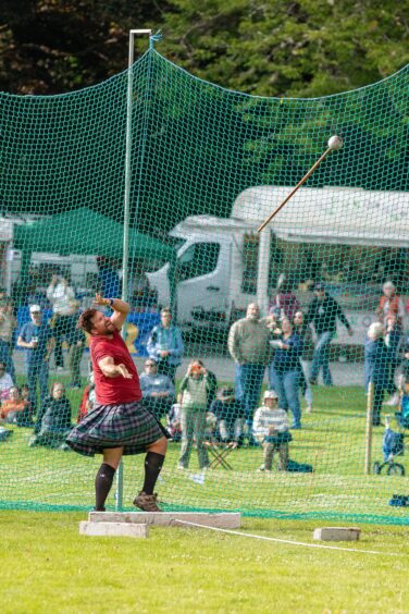 Heavy athlete in kilt throwing the hammer