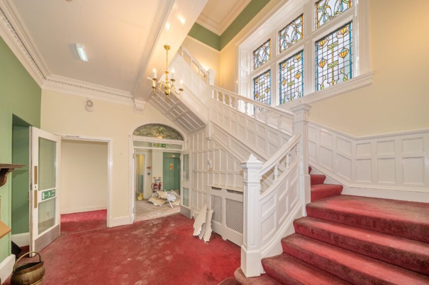 The main staircase with stained-glass window.