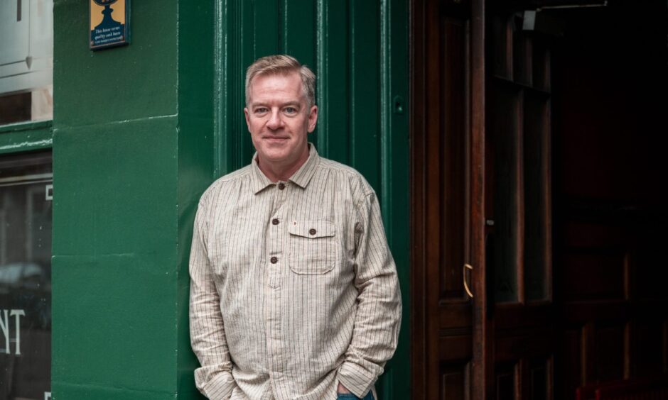 Charlie Connelly standing in the doorway of Mennies/The Speedwell Bar, Dundee