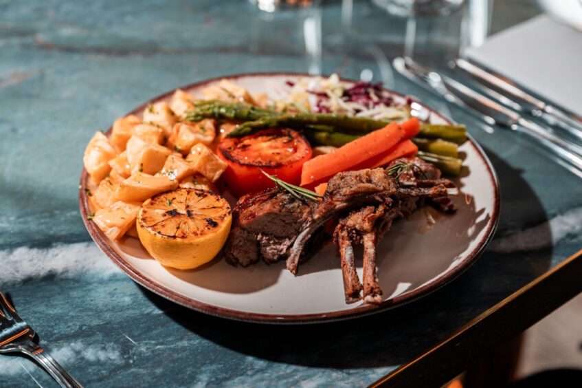 A dish of rack of lamb and patatas bravas.