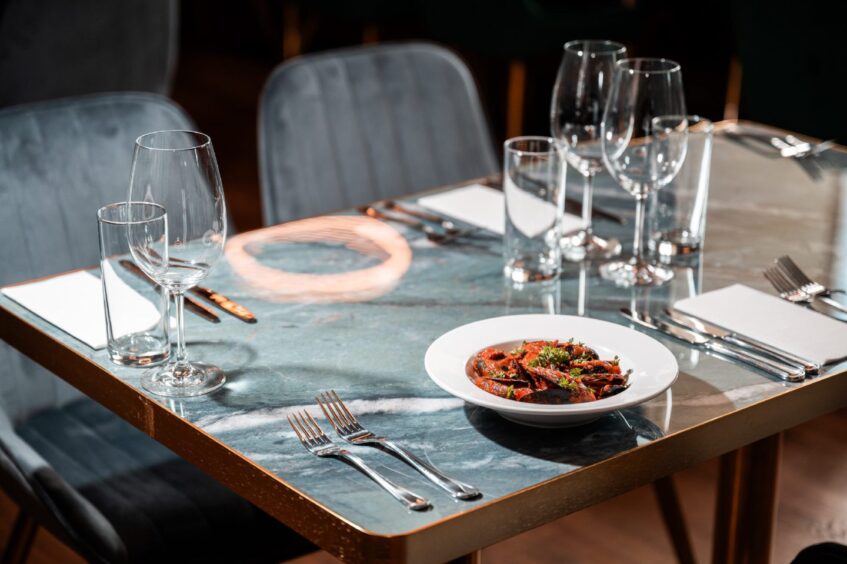 A table in 1876 restaurant with a dish of mussels on it.