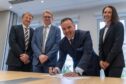 Mark Dyer and Wim Deschact of Daikin, Graeme and Leanne Carling of United Capital signing the sale of Saltire Facilities Management. Image: Supplied.
