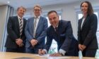 Mark Dyer and Wim Deschact of Daikin, Graeme and Leanne Carling of United Capital signing the sale of Saltire Facilities Management. Image: Supplied.