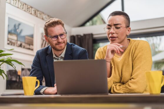 Focused short haired woman with glasses, discussing a project with her male coworker