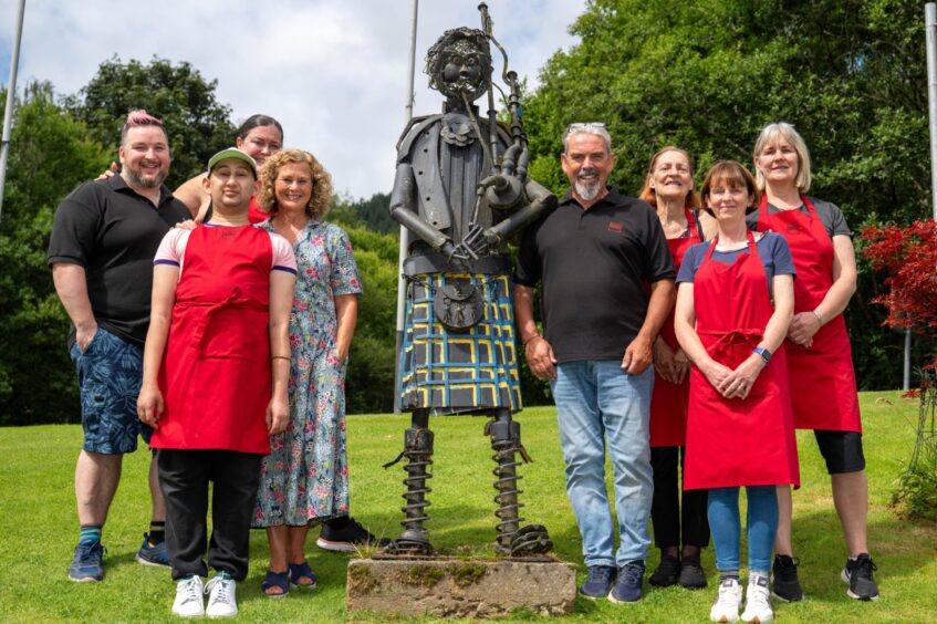 Group of people standing beside metal statue of piper