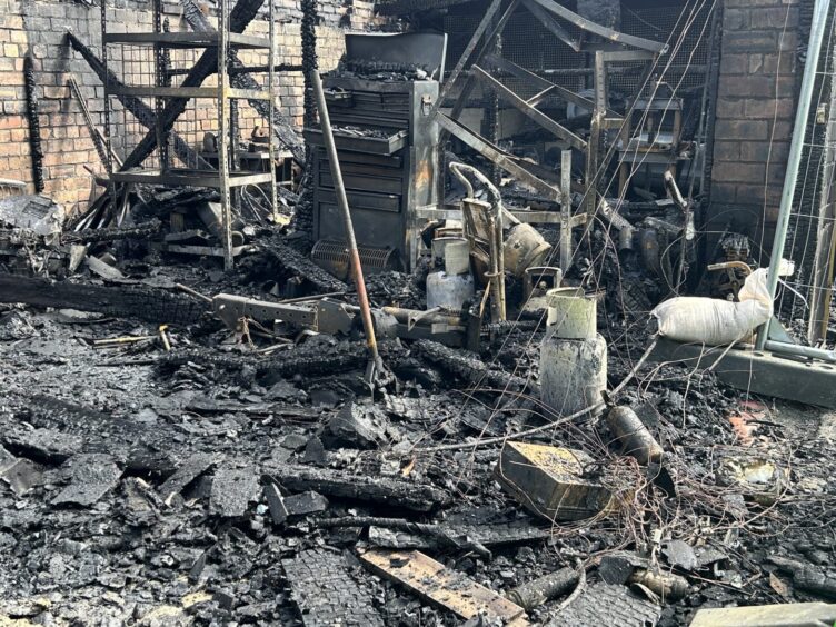 Fire-damaged gas bottles remain at the scene.