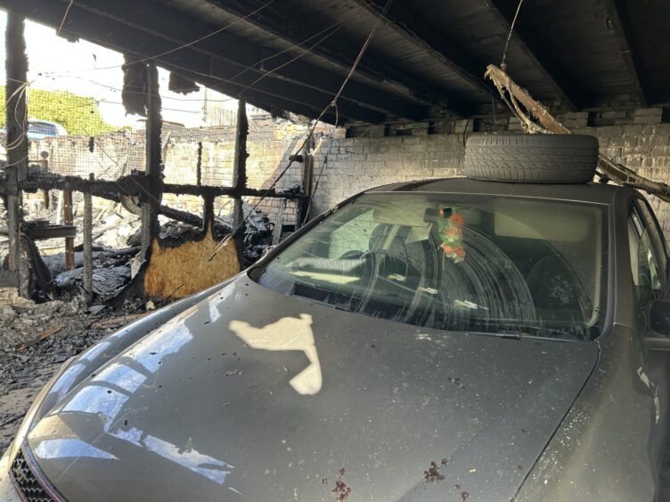 A car still parked in one of the garages destroyed by the fire.