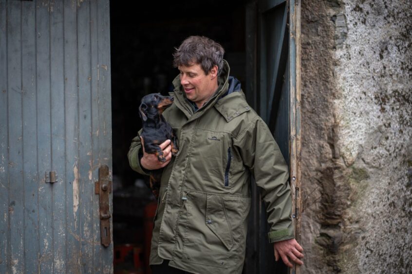 man-holding-small-dog-ahead-of-scone-palace-horse-trials