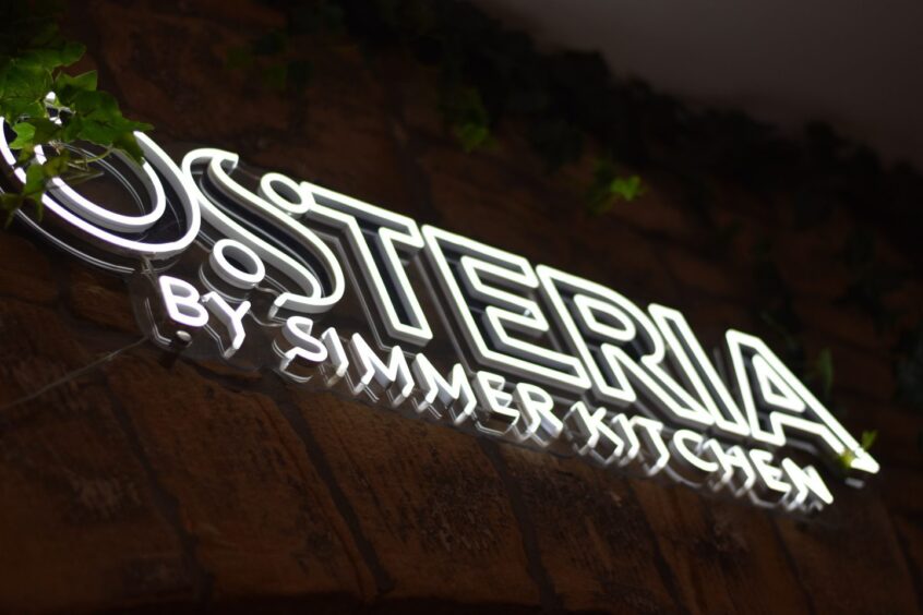 A neon sign that reads: "Osteria by Simmer Kitchen"