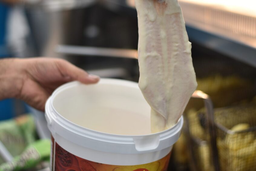 The haddock covered in raw batter.