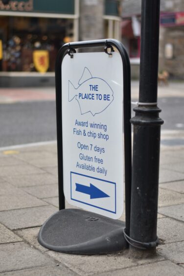 A sign advertising The Plaice To Be in Pitlochry.