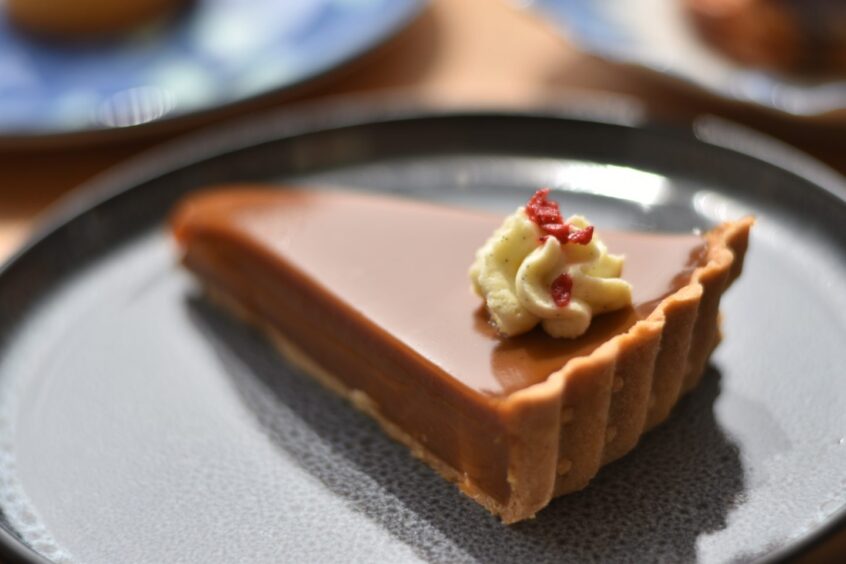 A slice of the salted caramel tart served on a plate.