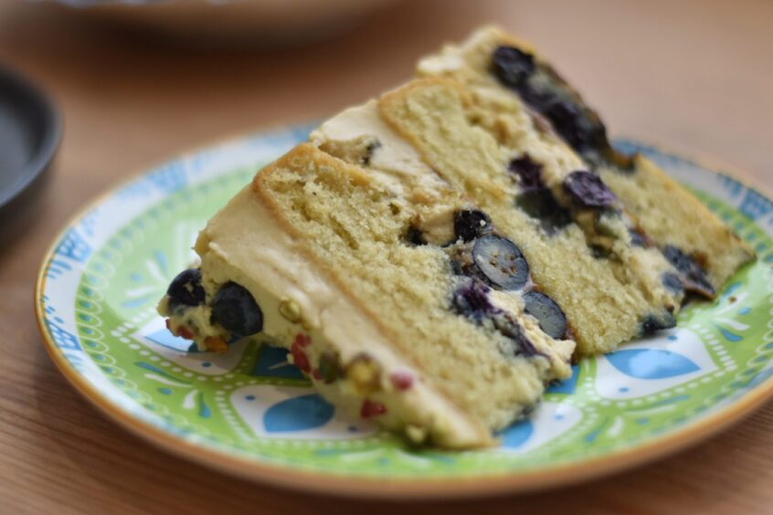 A slice of the pistachio praline and blueberry cake.