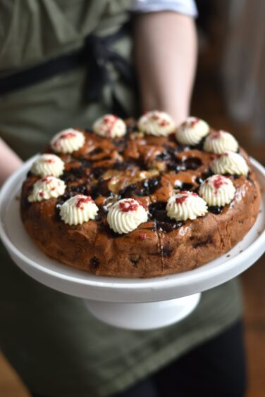 A cake being held by Emily Black.