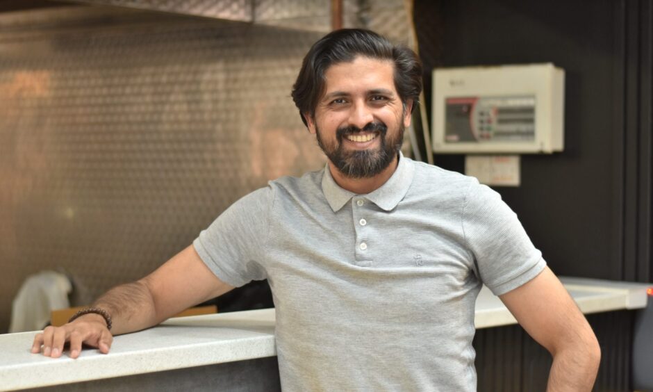 Fahad Usman, smiling in his restaurant.