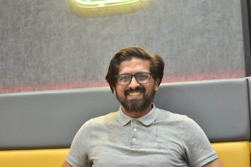 Fahad Usman smiling in his restaurant.
