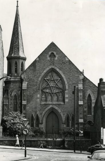 People walking past the church in Hilltown.