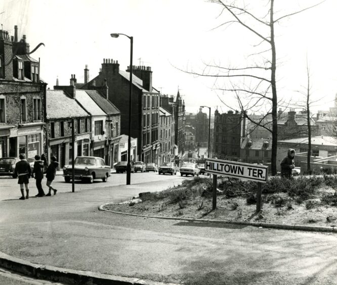 children stand on a street corner in this view of the Hilltown looking downhill into the Wellgate area.