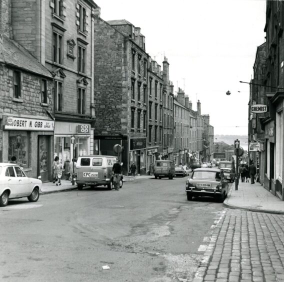 cars parked at the kerb in this street view in the Hilltown