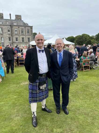 Roy Spiers and Roland Smyth with garden party guests and palace behind