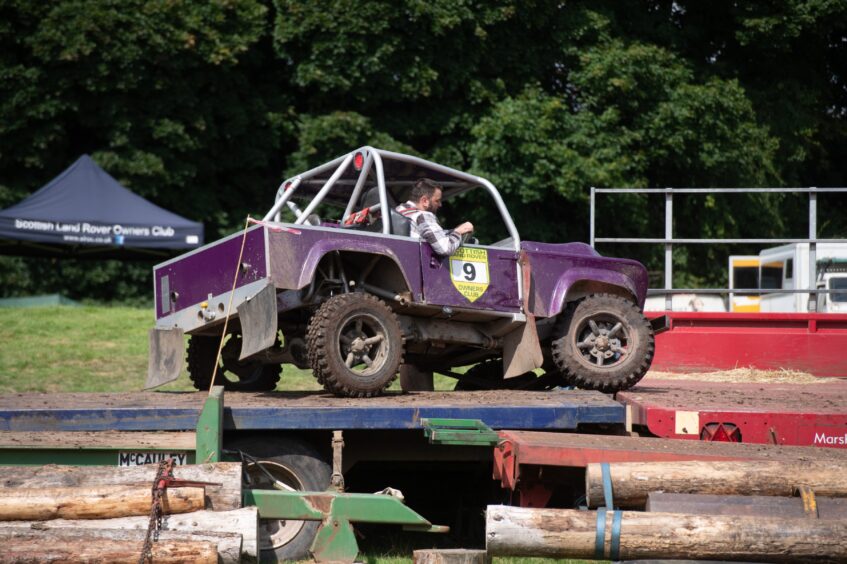 A man drives his Land Rover to show off its versatility on challenging terrain.